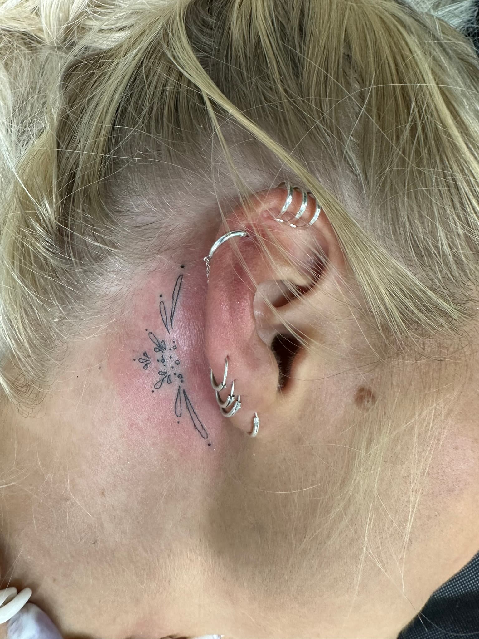 Fine line ornamental tattoo behind the ear by Isaac Mackenzie, Oahu