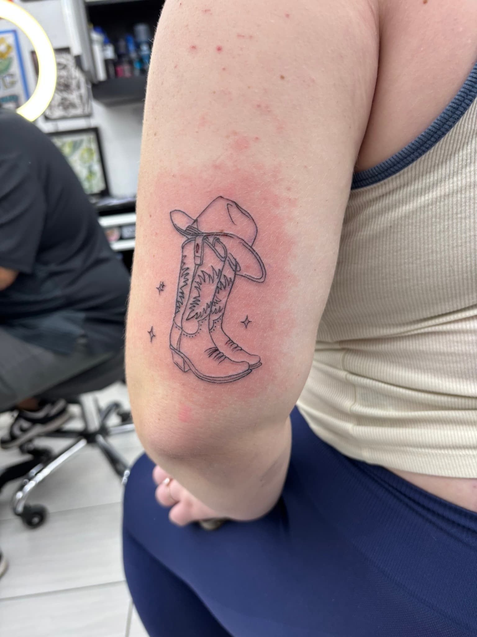 Fine line cowboy boots and hat tattoo by Isaac Mackenzie, Oahu