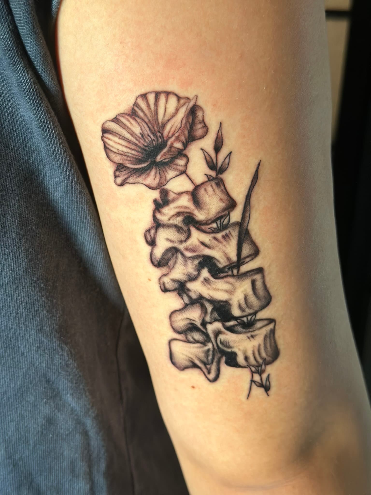 Fine line poppy spine tattoo by Isaac Mackenzie, Oahu