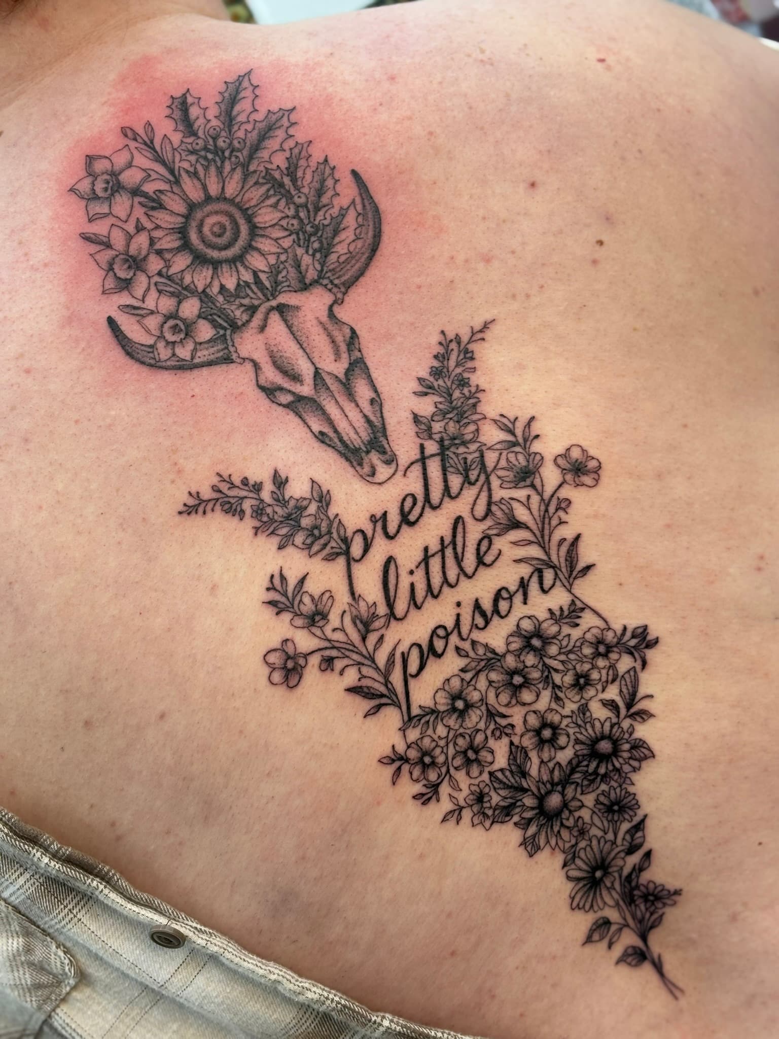 Fine line wildflower and steer skull back piece with script by Isaac Mackenzie at TNT Tattoo, Aiea, Oahu