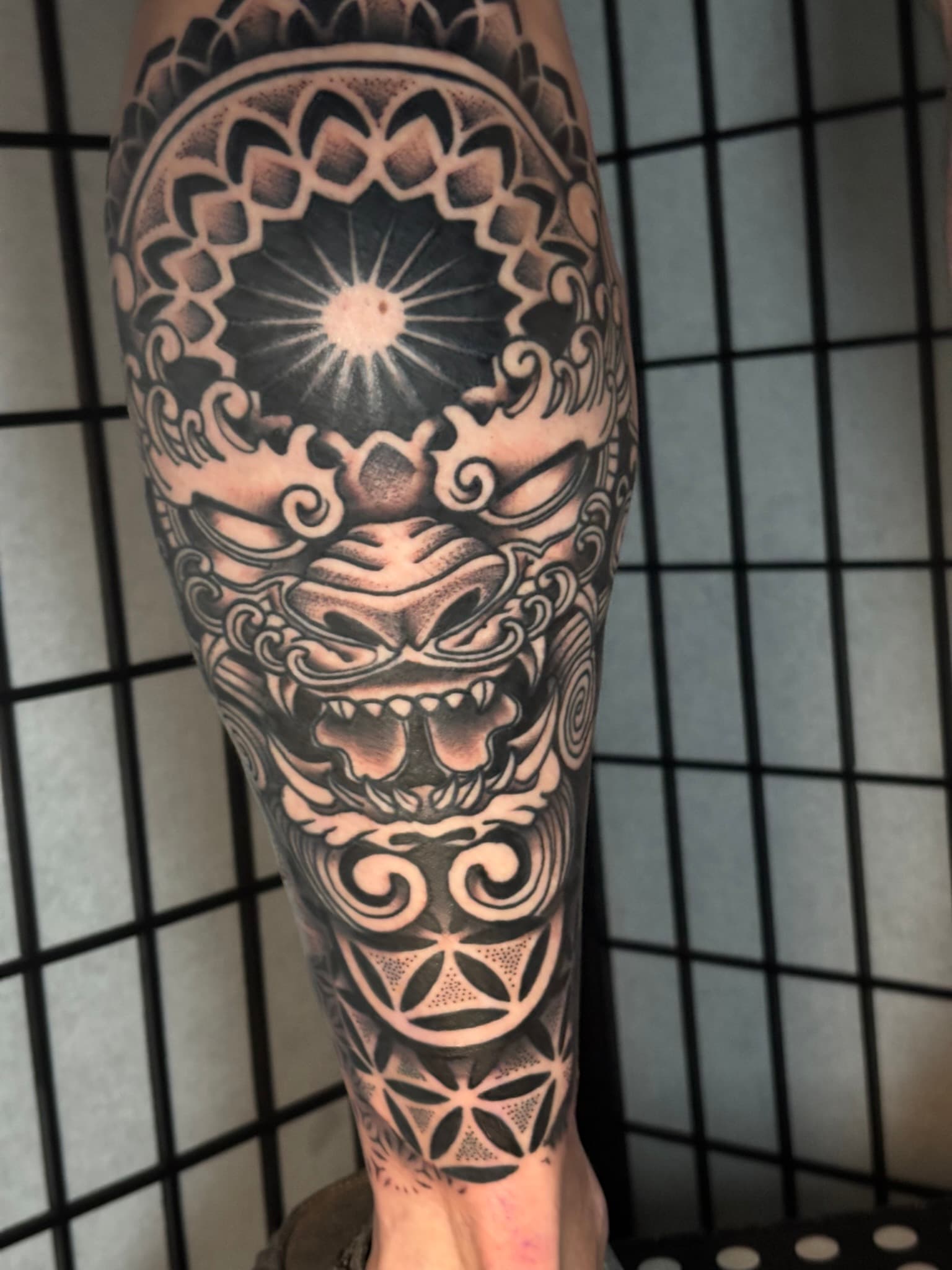 Geometric foo dog and seed of life mandala tattoo by Isaac Mackenzie