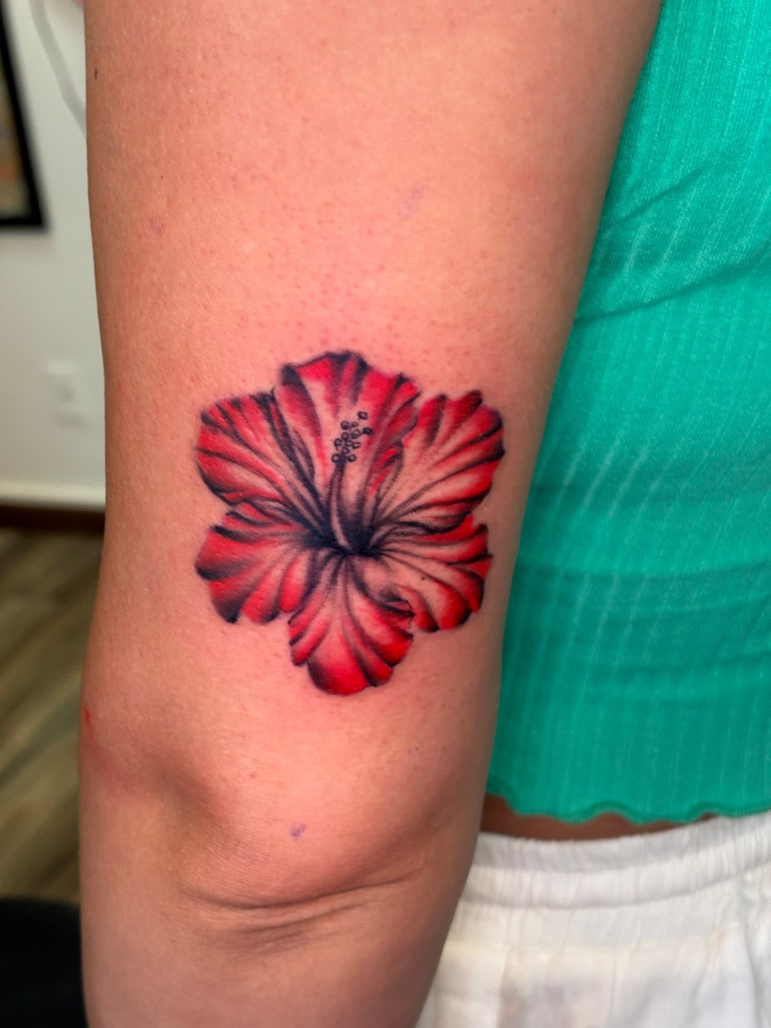 Small color hibiscus illustrative tattoo by Isaac Mackenzie, Oahu
