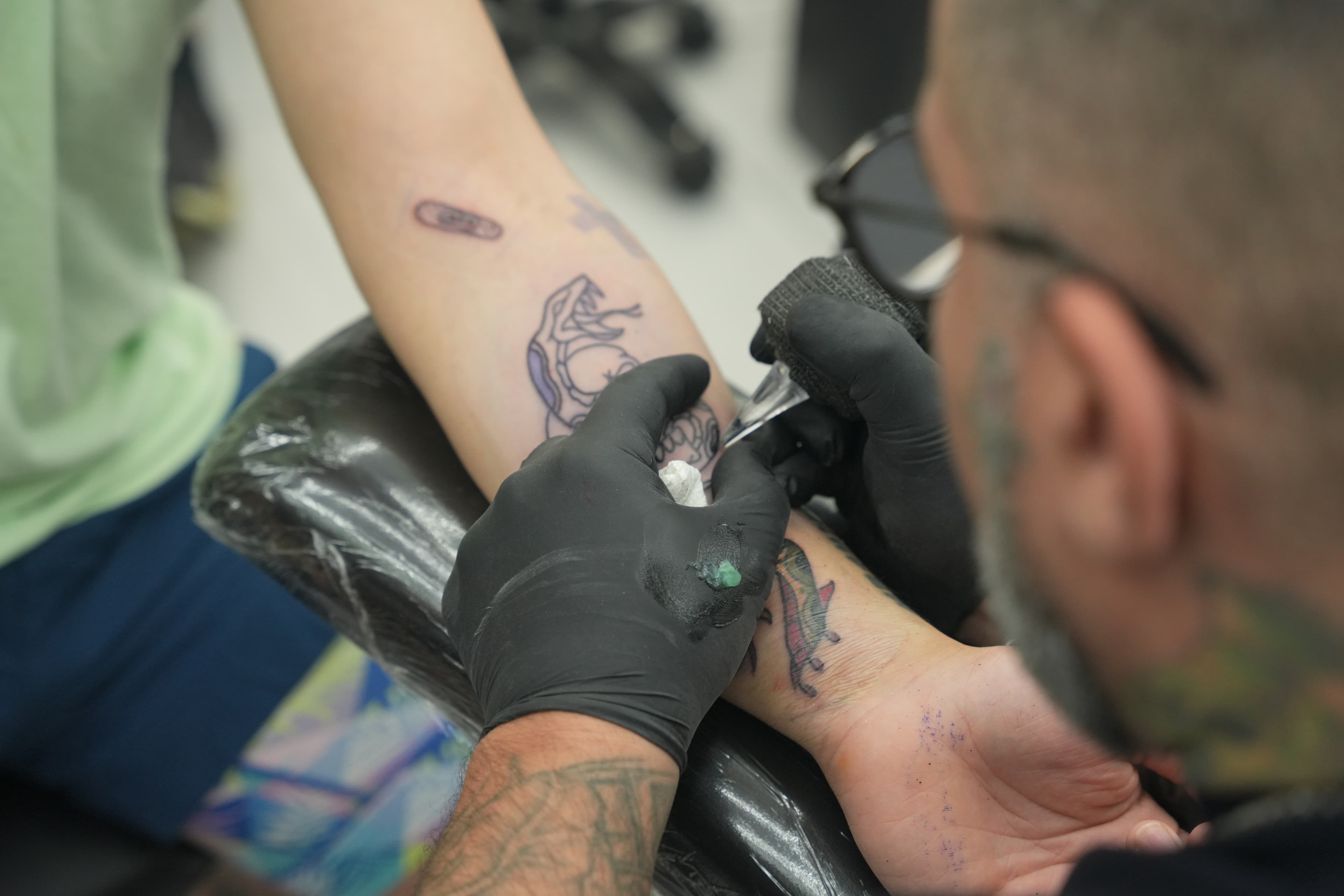 Over-the-shoulder view of Isaac Mackenzie working on a tattoo, Oahu Hawaii