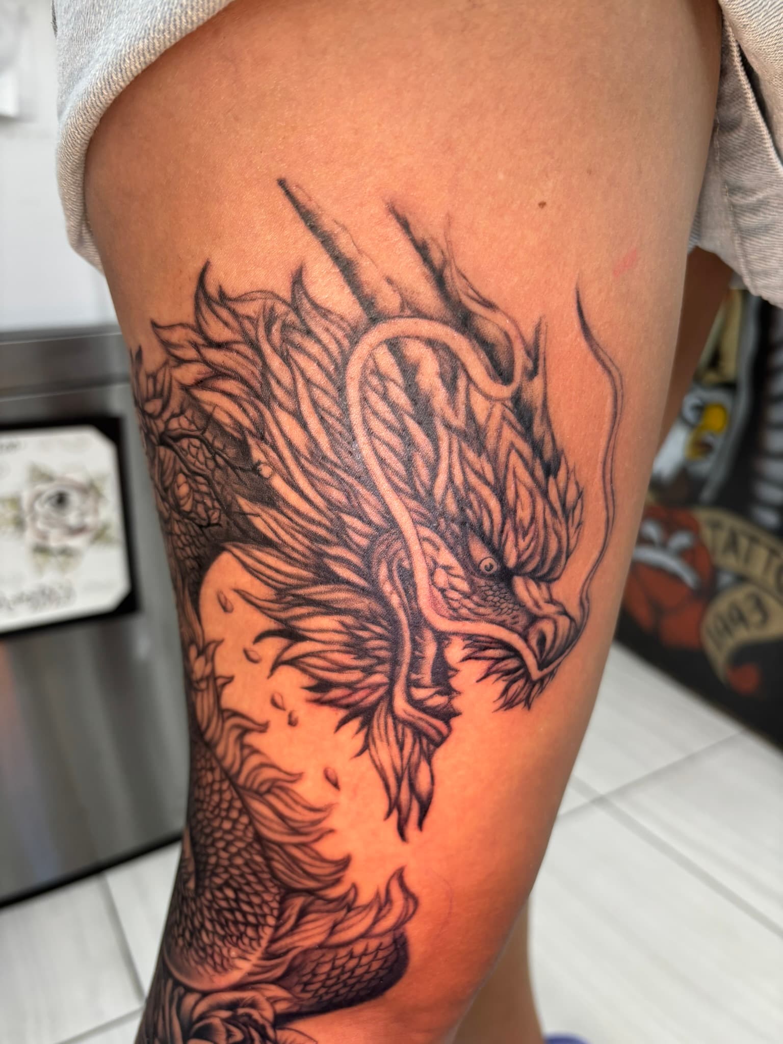 Japanese realism dragon with cherry blossoms and lotus tattoo by Isaac Mackenzie
