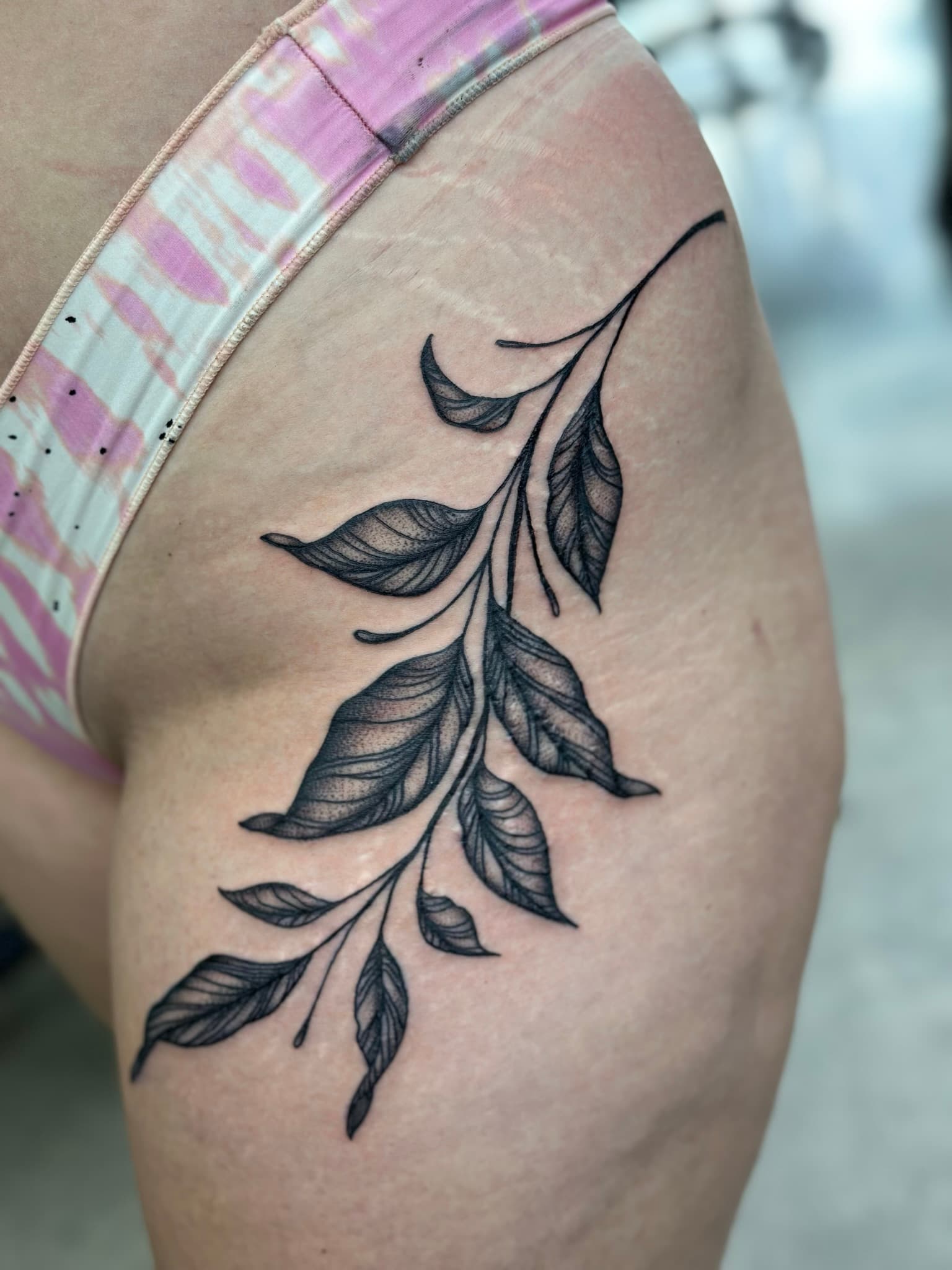 Neo-traditional branch tattoo on hip and thigh by Isaac Mackenzie