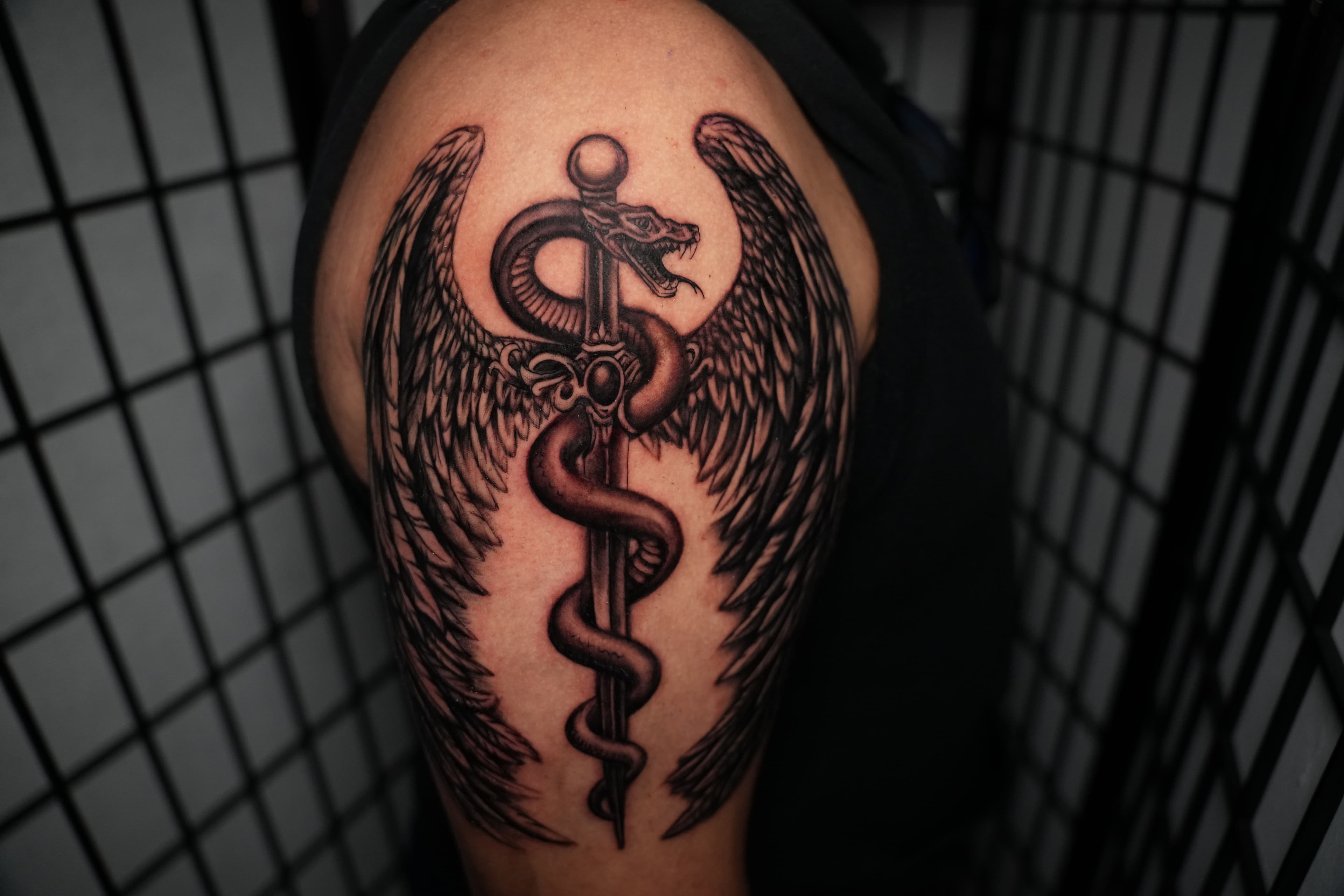 Realism caduceus with wings and sword tattoo