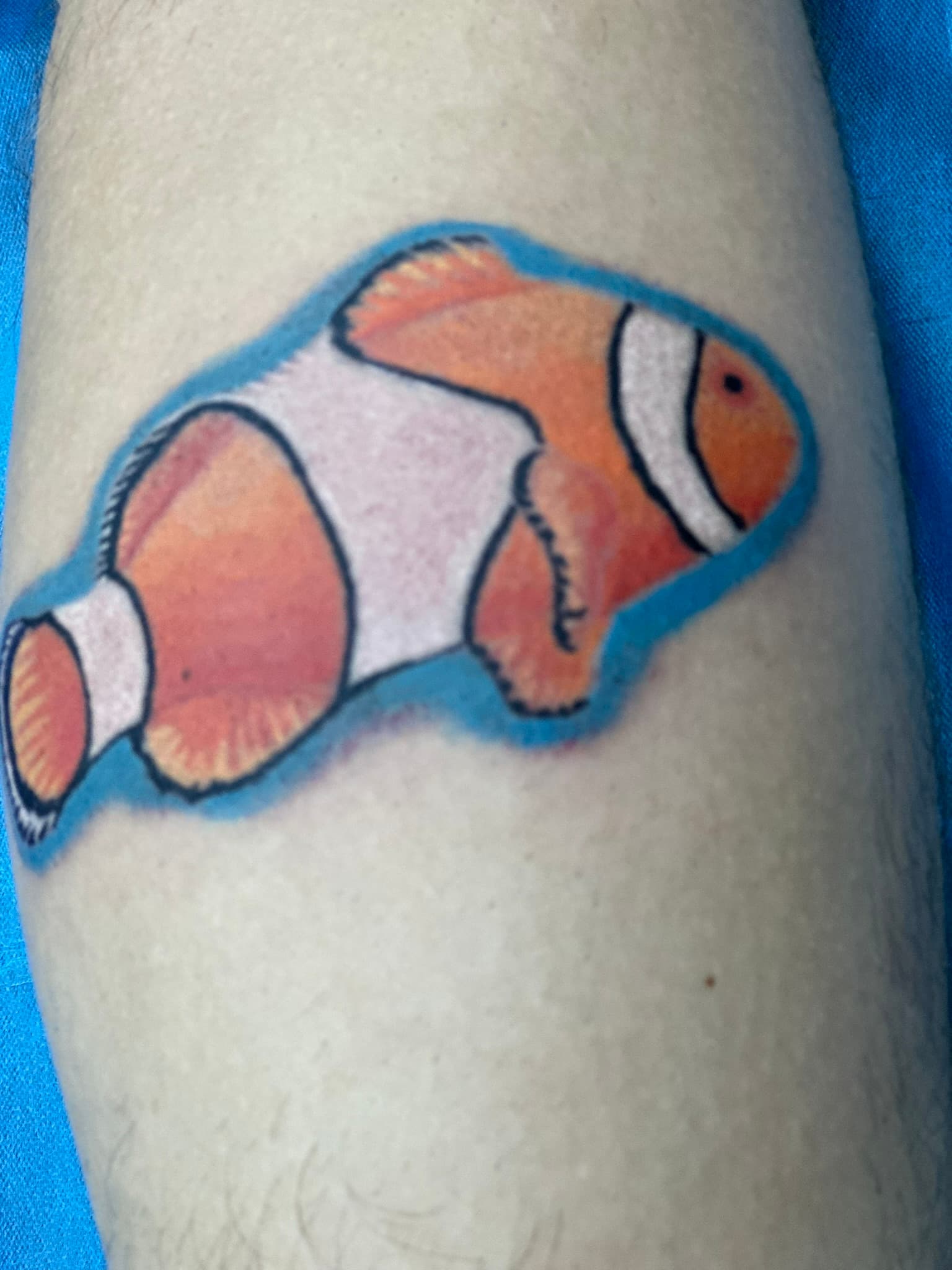 Color realism clownfish tattoo by Isaac Mackenzie Hawaii