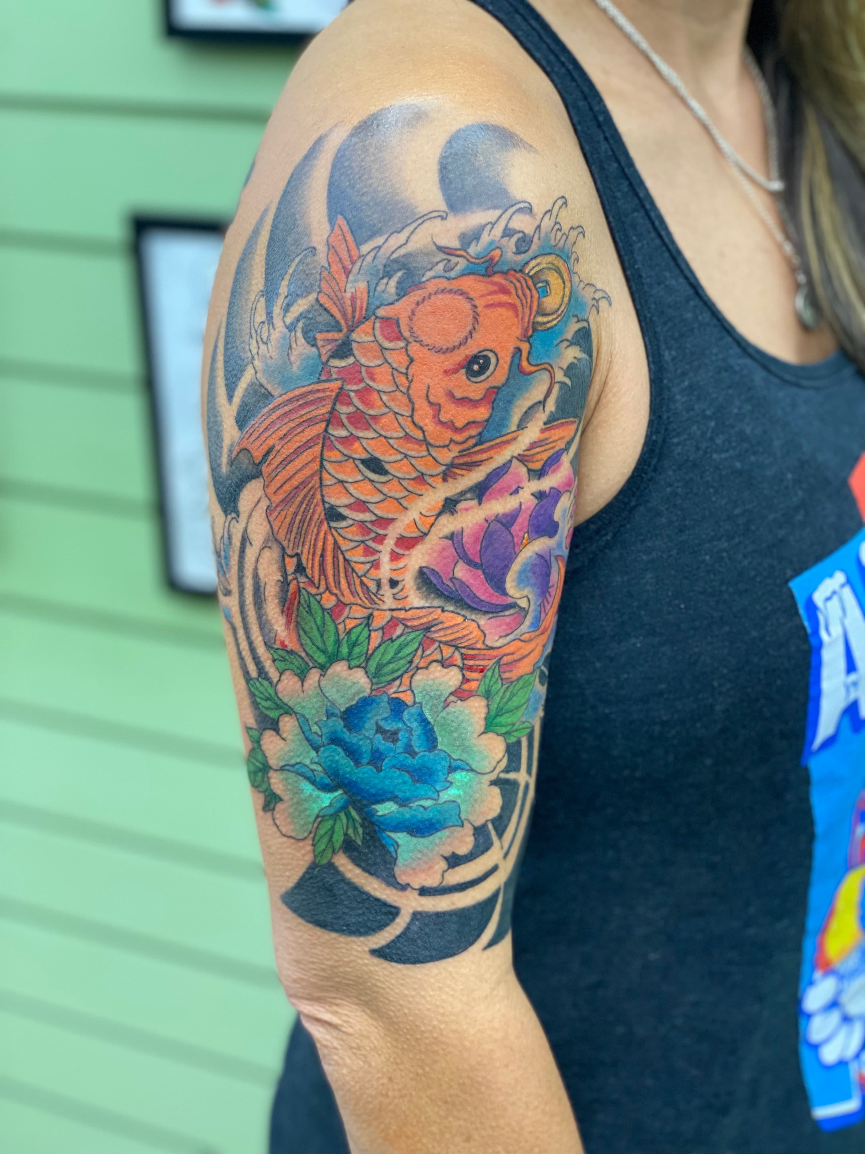 Full color American traditional koi and peony half sleeve tattoo by Isaac Mackenzie at TNT Tattoo, Aiea, Oahu